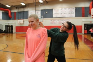 Seniors Holly Swaldi (left) and Annie Friedman (right) practice a self defense technique at the Coppell Middle School East gym.