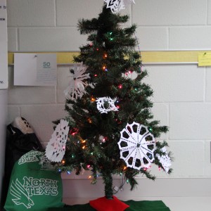 Coppell High School Sidekick newspaper staff members put up the christmas tree in D115 on Monday during class. Students came together to make snowflakes and ornaments during the holiday season to decorate the tree.  