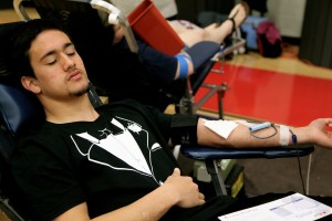 Senior Nathan Hernandez squeezes on a stress ball as he prepares to give blood Friday morning in the small gym for the Public Service Academy blood drive. Photo by Rachel Bush.