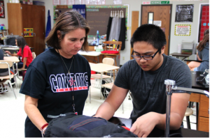 Freshmen biology teacher Mrs. Douglas works with student Austin Banzon to create an iPad presentation about the characteristics of living things on Friday. Photo by Alyssa Frost.