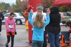 Junior Jessie Cranmer high fives fourth grader Abby Hendricks as they cross the finish line at the Gobble Hobble 5K on Nov. 23. Photo by Elizabeth Sims.