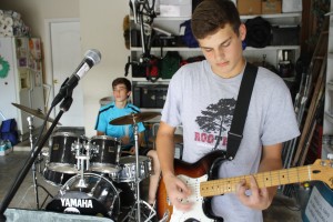 The band Auto practices in their garage after school.