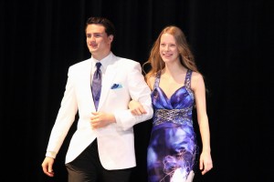 Seniors Kilian Bresnahan and Allie Zill walk across the stage at the prom fashion show on Wednesday in the auditorium. Photo by Regan Sullivan.