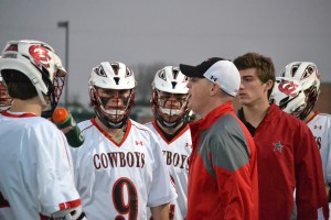 Head coach Alexander Poole discusses game strategy during a time out in the second quarter. The Cowboys fell to the Highland Park Scots, 8-5.