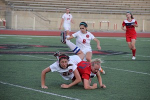 Junior forward Sarah King dives for the ball as junior mid-left Cami Studebaker comes up behind her at the first playoff game against Grapevine on Friday. Coppell took the win 1-0. Photo by Alyssa Frost.