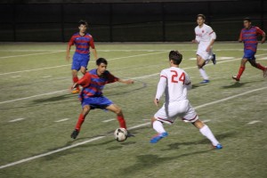 Coppell junior forward Colten Clark manuevers the ball around a Duncanville player in Tuesday's regional quarterfinal match at Birdville ISD Fine Arts/Athletic Complex. Coppell defeated Duncanville 2-0. Photo by Shannon Wilkinson.  