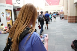 CHS student checks social media during passing period. Photo by Sandy Iyer