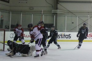 Sophomore Brandon Johnston controls the puck around the net during a game against Southlake Carroll. Coppell won the game 7-1. Photo by Stephanie Alexander.