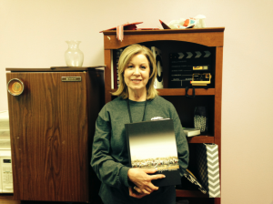 Round-Up yearbook teacher Sallyanne Harris holds last year's award winning book in the yearbook room.  Harris and the staff will travel to the state ILPC convention in Austin in hopes of securing more awards. Photo by Summer Crawford. 