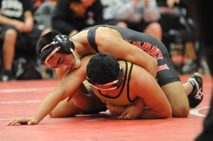 Senior David Murillo works to pin his opponent during the wrestling team's Senior Night on Jan. 29 in the small gym at Coppell High School. Photo by Sarah VanderPol.