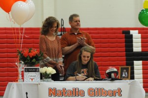 Senior Natalie Gilbert signs her letter of intent with the family behind her. Gilbert is committed to the University of Texas. Photo by Sarah VanderPol.