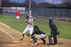 Junior pitcher Marco Navarro starts his swing Friday night during a home district game against the Southlake Dragons. Coppell won 3-2, and Navarro recorded a hit and one RBI in the game. Photo by Aubrie Sisk. 