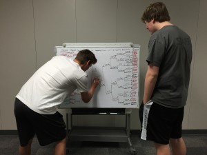 Senior Nick Wilson and sophomore Spencer Hicks finish filling out their bracket. The round of 64 begins on Thursday, March 19 at 11:15 a.m. Photo illustration by Nicole Messer.