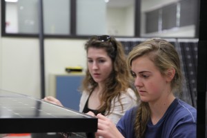 Seniors Andrea Clark and Olivia West add the finishing nuts and bolts to the solar powered car that the STEM team built. This was Andrea’s second year on the Solar Car team and Olivia’s fourth year. Photo by Aubrie Sisk. 