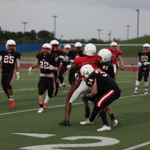 Sophomore Matthew Frappier and sophomore Preston Rutherford tackle opposing player during the Spring Game Thursday night at Coppell High School. The cowboys defense and offense scrimmaged against each other. Photo by Aubrie Sisk.