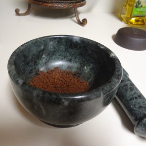 If the coffee grains are not finely ground, crush them into a powder with the mortar and pestle. 