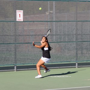 CHS junior Laila Kamel swings to hit the ball in her doubles match against Southlake Carroll, which she played with her partner CHS senior Joy Johnson and lost her doubles match but won her singles. The Cowboys played the Dragons at home for their final district game on Tuesday and finished district runner ups. Photo by Kelly Monaghan.
