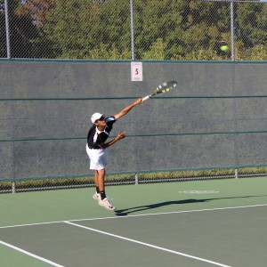 CHS  sophomore Brian Nguyen serves the ball during the Cowboys’ match on Tuesday at the Coppell High School Tennis Center. Nguyen played his doubles match with his partner CHS sophomore Justin Chen. Photo by Kelly Monaghan.