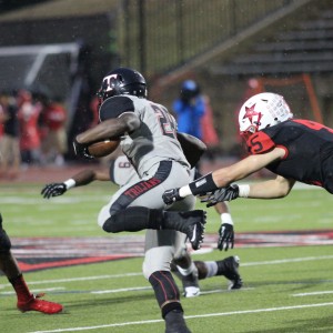 Coppell High School senior and defensive back Kyran Jamison chases after Trojan senior and running back Ja'Ron Wilson as he goes for a touchdown during the second quarter during Friday night's game. After many weather delays, Trinity defeated the Cowboys with a final score of 49-14 at Buddy Echols Field. Photo by Amanda Hair.