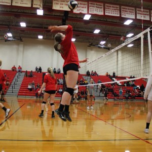 Coppell High School sophomore Breanne Chausse spikes the ball while warming up to defeat Trinity High School. The Cowgirls won all three sets, the first with a score of 25-9, 25-17, and 25-11 on Friday night's game in the CHS large gym. Photo by Megan Winkle. 