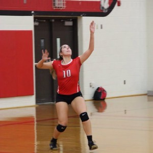 Coppell High School senior Caroline Riley serves the ball to begin the set against the Trojans. The Cowgirls won all three sets, the first with a score of 25-9, 25-17, and 25-11 on Friday night's game in the CHS large gym. Photo by Megan Winkle. 