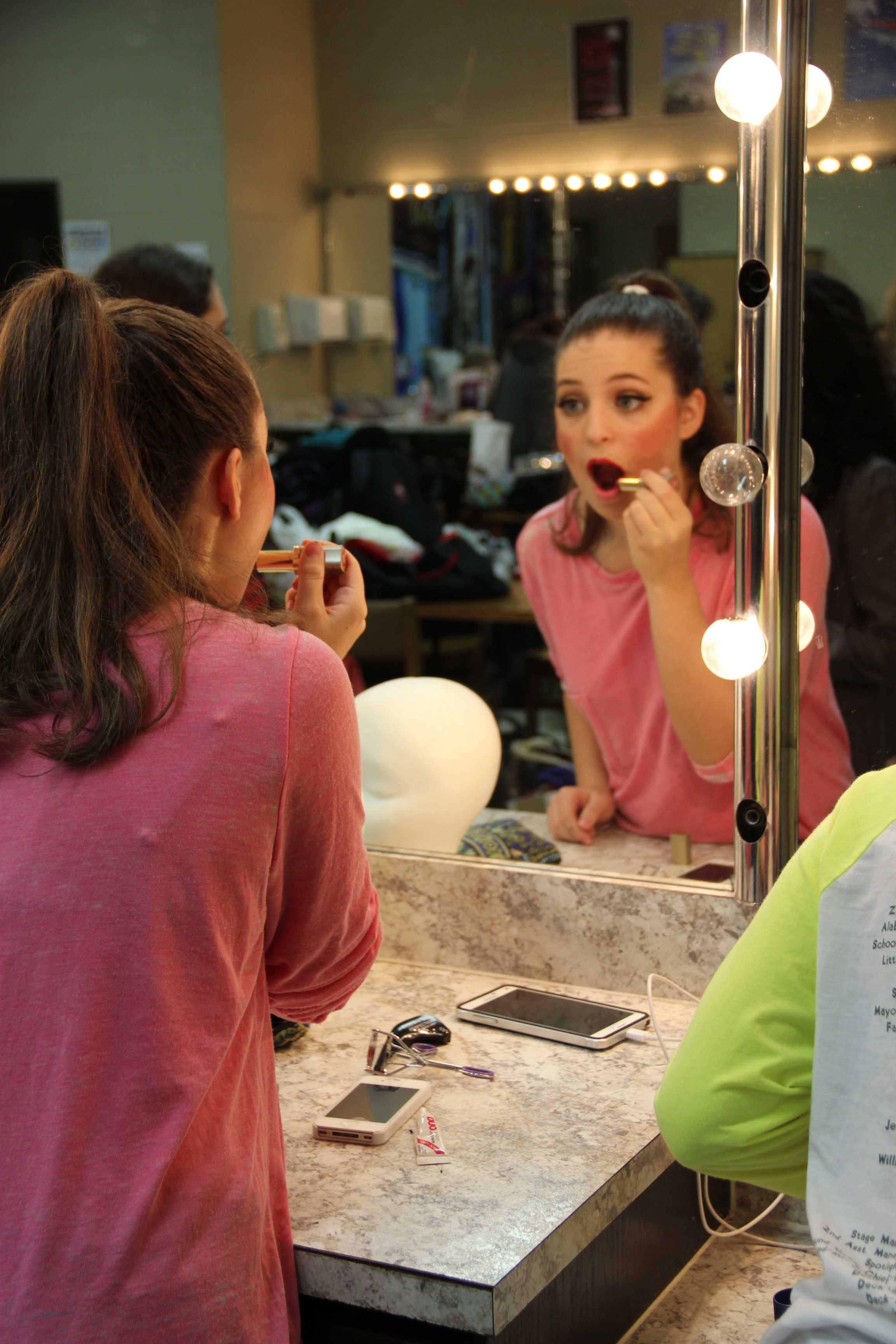 Junior Natalie Weix applies lipstick in the Green Room in preparation for her performance in “Big Fish” the musical at Coppell High School on Oct. 30. “Big Fish” is the fifth show Weix has been in at CHS and the third musical. She played an Alabama Lamb and was a member of the ensemble in Big Fish. Photo by Maggie Theel.