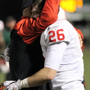Coppell High School senior Drew Smith shares a hug with offensive coach Jay Jones after the Coppell Cowboys lost to the DeSoto Eagles. The Cowboys' lost with a final score of 35-31, ending their season on Friday night at Eagle Stadium. Photo by Amanda Hair.