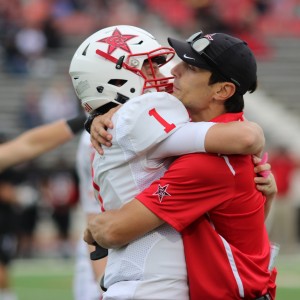 Coppell High School sophomore Wiley Green and wide receiver coach Nate Blackwell share a hug after Green completed the final play in Saturday’s game against the Colleyville Heritage Panthers at the Mustang-Panther Stadium. Coppell ended the game with a victory over Colleyville Heritage, the final score being 19-14. Photo by Amanda Hair. 