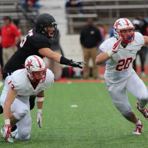 Coppell High School junior Ryan Jones (left) and CHS senior Daniel Storie (right) both rush to tackle Colleyville Heritage senior Tommy Hall as he goes for a touchdown at the beginning of the third quarter of Saturday’s game. Coppell defeated the Panthers with a score of 19-14 at the Mustang-Panther Stadium. Photo by Amanda Hair. 