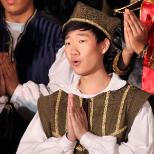 During the first Madrigals performance on Friday night, Coppell High School junior Daniel Kim sings the second song of the night in the CHS large commons. People all across Coppell gathered to enjoy the students’ show and ate dinner while doing so. Photo by Amanda Hair.  