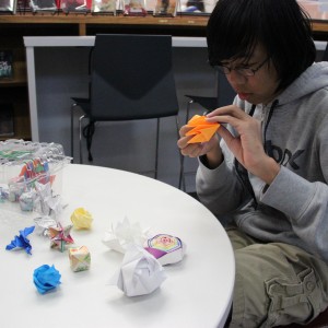 Coppell High School sophomore Frank Zhang folds an origami laser cannon in the school library on Nov.18. Zhang invented the model for a laser cannon based on an online instruction for an origami spider. Photo by Ayoung Jo.