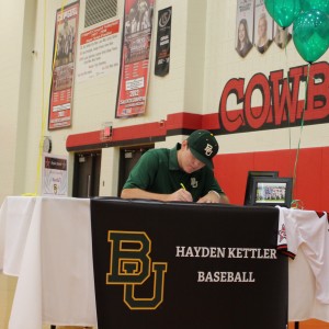 Coppell High School varsity pitcher and infielder Hayden Kettler signs to Baylor University for baseball in the CHS large gym on Nov. 11. Nine CHS athletes gathered on National Signing Day to sign their letters of intent to play sports in college. Photo by Kelly Monaghan.