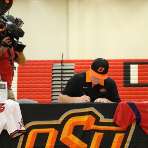 Senior Chris Burdine signs to Oklahoma State University for baseball on Nov. 11, National Signing Day, in the Coppell High School large gym. Five CHS students signed their letters of intent to play baseball in college, eight students signing in total. Photo by Kelly Monaghan.