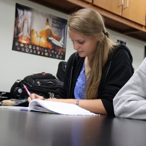 Karl Gscheidle’s physics class tests student made catapults Monday in the main hallway of Coppell High School. Junior Brooke Davidson records data and prepares to write her group's lab report after finishing their experiment. Photo By Chelsea Banks. 