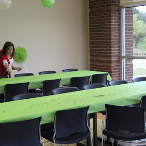 Volunteer Marissa Sorrells prepares for the Santa’s Workshop event by sprinkling paper confetti on tables in the recreation room of the CORE, Coppell’s aquatic and recreation center, on Dec.12. Sorrells came to help out with the event with her grandmother, Shelley Abraham, who is the Recreation Supervisor at Coppell Parks and Recreation Department. Photo by Ayoung Jo.