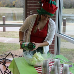 Volunteer Morgan Maxwell prepares the “Grinch Juice” for the children and their parents at the Santa’s Workshop at the CORE, formerly known as Coppell Aquatic and Recreation Center, on Dec.12. Maxwell made the “Grinch Juice” by combining a green icecream with Canada Dry soda. The attendees enjoyed the “Grinch Juice” and cookies while they waited for the Grinch to come in the room. Photo by Ayoung Jo. 