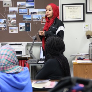 Coppell High School junior Mona El-Gharby explains the mission and upcoming projects of the Humanitarian Society of Coppell during the club meeting on Tuesday. The club’s focus is helping Syrian refugees in the DFW area. Photo by Ayoung Jo.