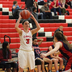 During the second quarter of Friday night’s game, Coppell High School junior Abby Johnson looks to pass the ball in the CHS large gym. The Cowgirls ended the game with a score of 51-28, defeating John Paul II. Photo by Amanda Hair. 