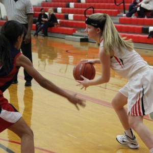 During the first quarter of Friday night’s game, Coppell High School junior Paige Haas tries to shoot the ball as she is being guarded. Coppell defeated John Paul II with a score of 51-28 in the CHS large gym. Photo by Amanda Hair.