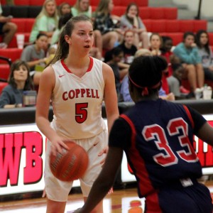Coppell High School junior Emma Johnson looks to pass the ball, which will later be received by junior Chidera Nwaiwu during the beginning of the second quarter. Friday night’s game ended with a score of 51-28, Coppell defeating John Paul II. Photo by Amanda Hair.