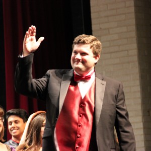 Coppell High School choir director Josh Brown motions for the audience to clap for the Madrigals choir that just finished their last song of Tuesday night’s winter concert. The show began at 7:30 p.m. in the CHS auditorium, where a variety of choirs performed. Photo by Amanda Hair.