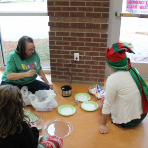 Recreation supervisor Shelley Abraham makes snacks in preparation for the Santa’s workshop event at the CORE, formerly known as Coppell Aquatic and Recreation Center, on Dec.12. Abraham made “marshmallow pops” by sticking large marshmallows on colored straws, dunking them in green candy melts and covering them with sprinkles. Photo by Ayoung Jo.