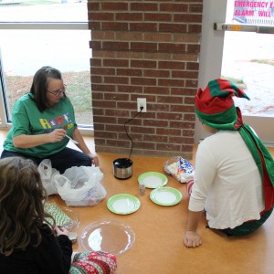 Recreation supervisor Shelley Abraham makes snacks in preparation for the Santa’s workshop event at the CORE, formerly known as Coppell Aquatic and Recreation Center, on Dec.12. Abraham made “marshmallow pops” by sticking large marshmallows on colored straws, dunking them in green candy melts and covering them with sprinkles. Photo by Ayoung Jo. 