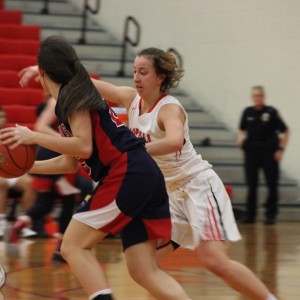 oppell High School junior Emma Johnson tries to steal the ball from the John Paul II Cardinals, ending the first half of Friday night’s game with a score of 27-18. The Coppell Cowgirls defeated the John Paul II Cardinals with a final score of 51-28 in the CHS large gym. Photo by Amanda Hair. 
